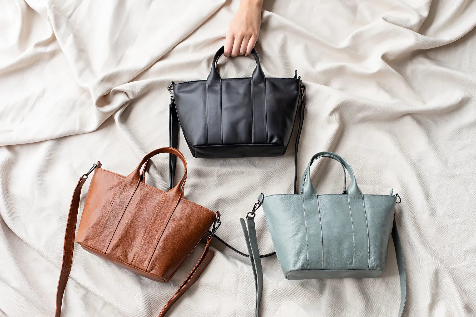 Bolsos refinados en tonos neutros sobre una tela suave