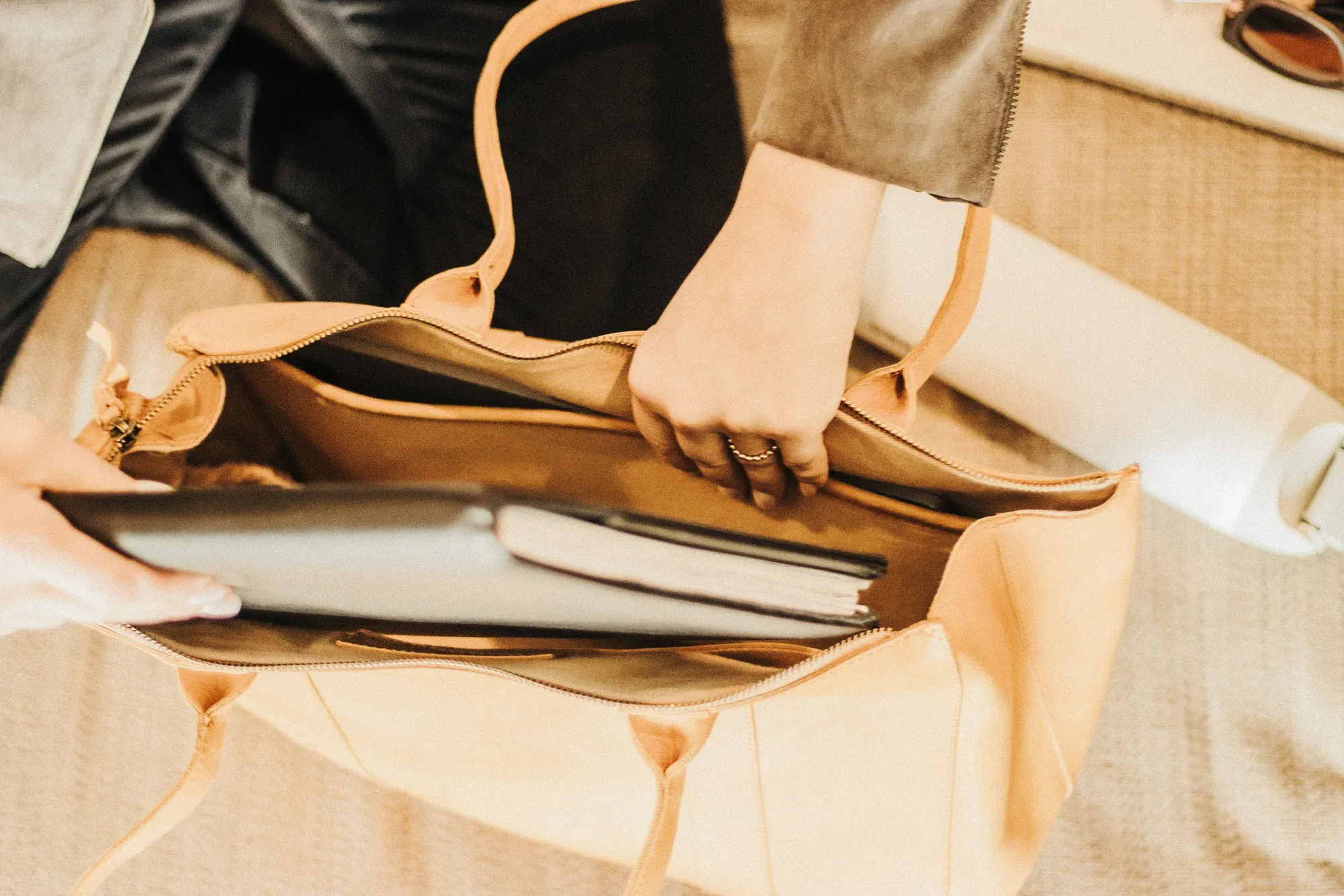 Bolso de cuero con computadora portátil y cuaderno